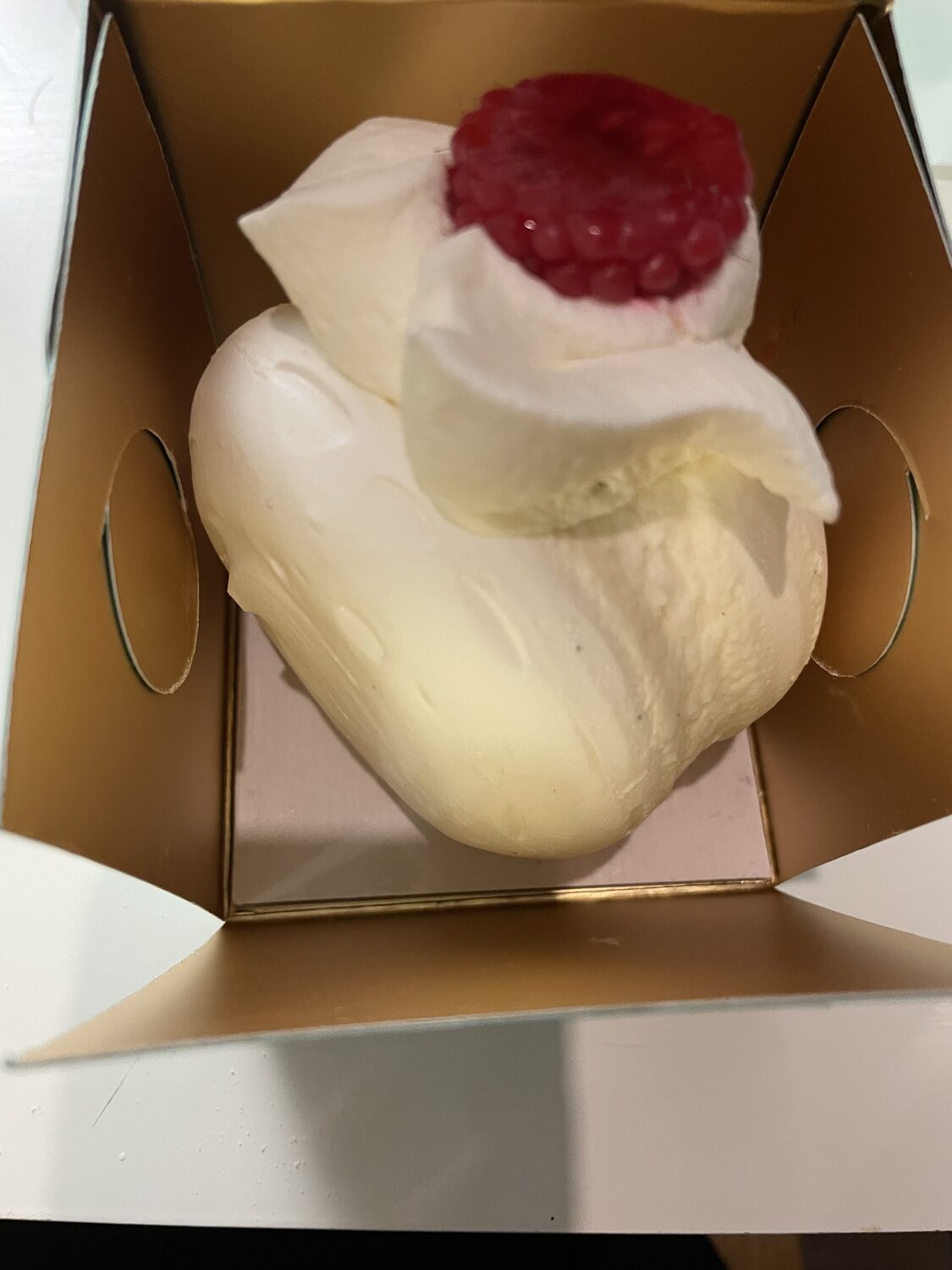 Un dolce con panna e un cuore di frutta rossa